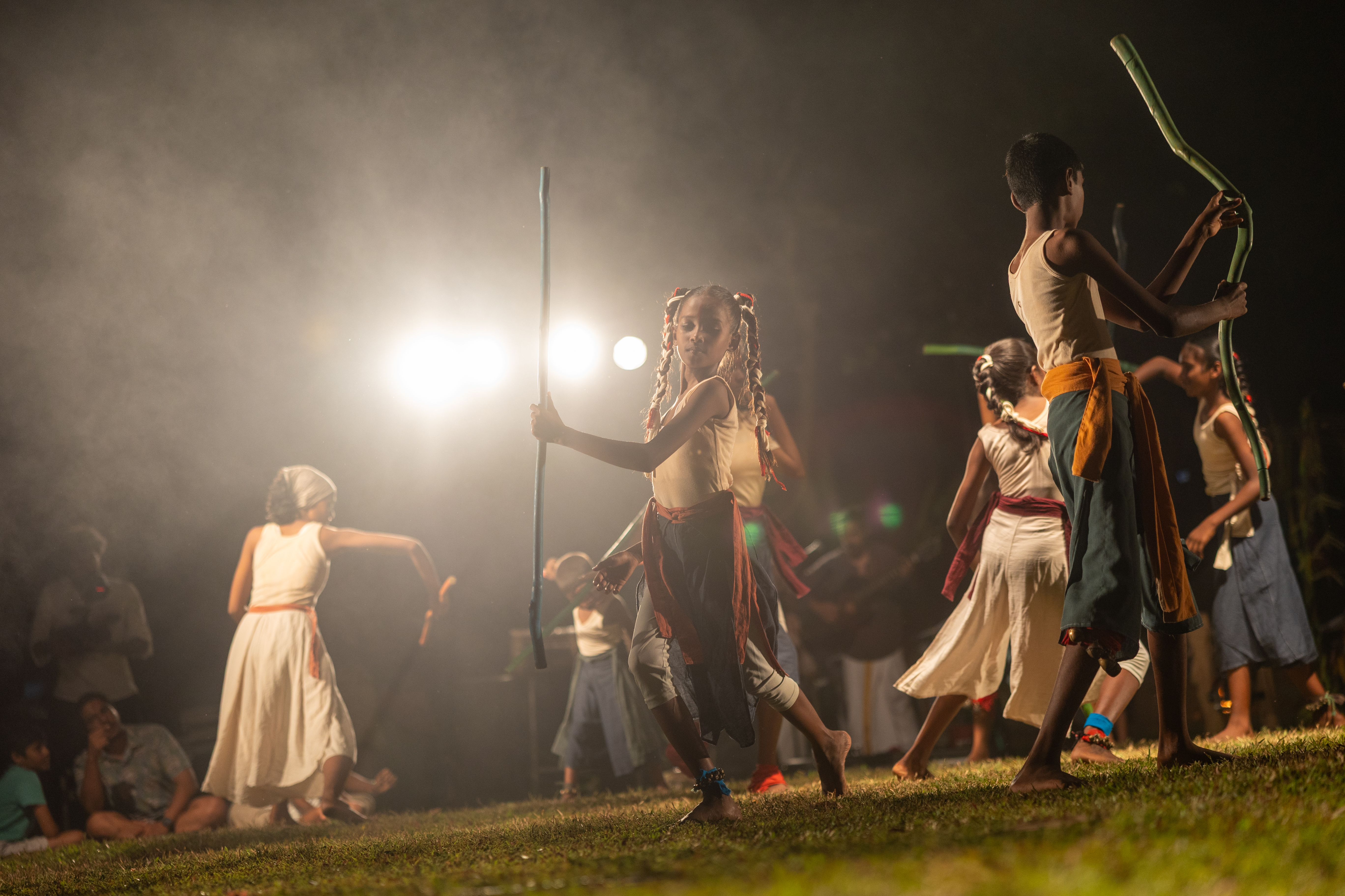 Children performing with sticks in smoky light